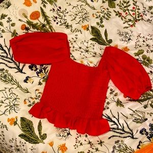 A Georgia red blouse from Fashion on Earth. Pleated with puffy sleeves and flare